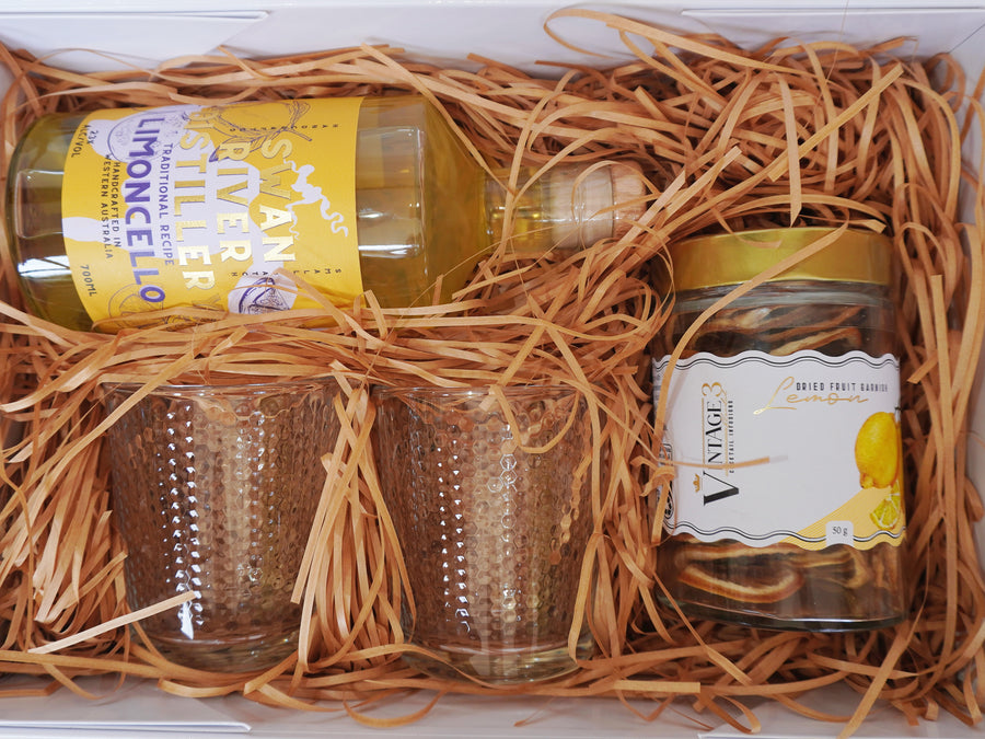 Gift box with Swan River Distillery limoncello, two textured tumblers and a jar of dried lemon garnish on natural straw filler, by No Matter What Gift Box Perth
